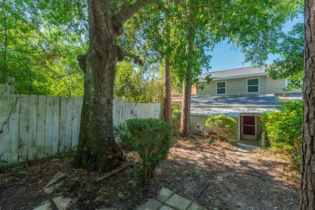 a view of a house with brick walls and a large tree