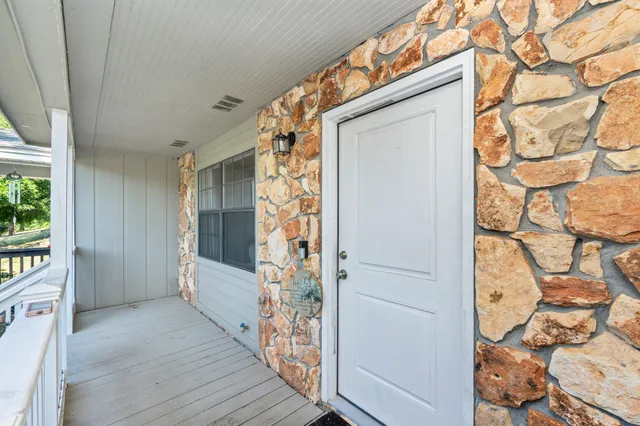 a view of a porch with wooden floor and a tree
