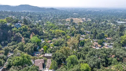 an aerial view of house with yard and mountain view in back