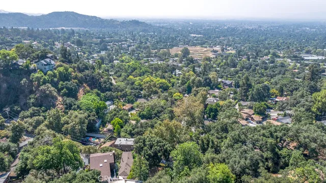 an aerial view of house with yard and mountain view in back