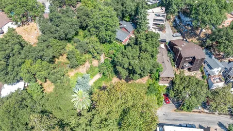 an aerial view of residential house with outdoor space and trees all around