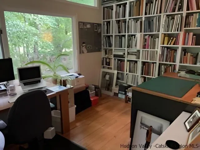 a view of a workspace with furniture and a bookshelf