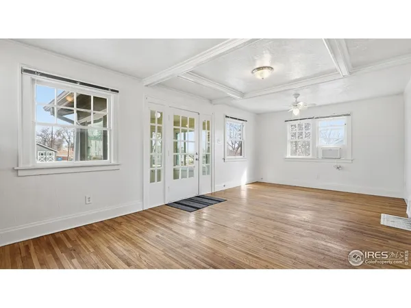 a room with wooden floor and windows