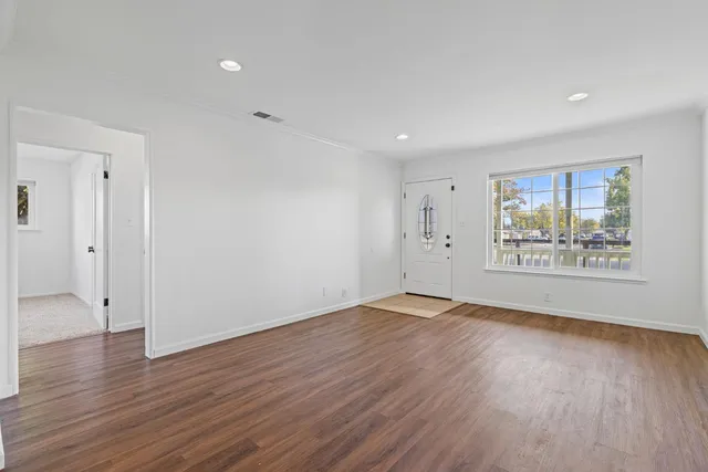 an empty room with windows and fan
