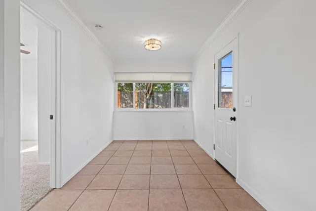 an empty room with ceiling fan and window