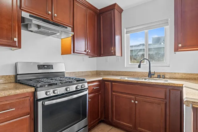 a view of an empty room with wooden floor and windows