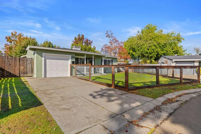 a view of a house with backyard sitting area and garden
