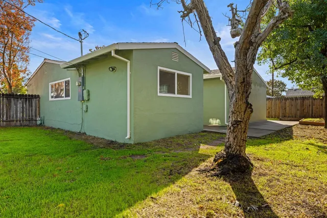 a backyard of a house with table and chairs