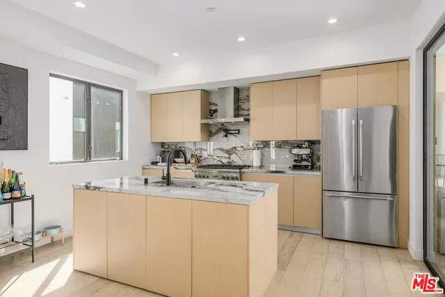 a kitchen with stainless steel appliances granite countertop a stove a sink and a refrigerator