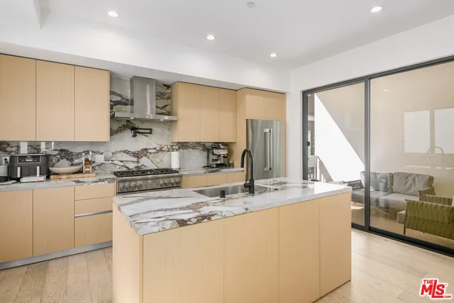 a kitchen with kitchen island a dining table and chairs