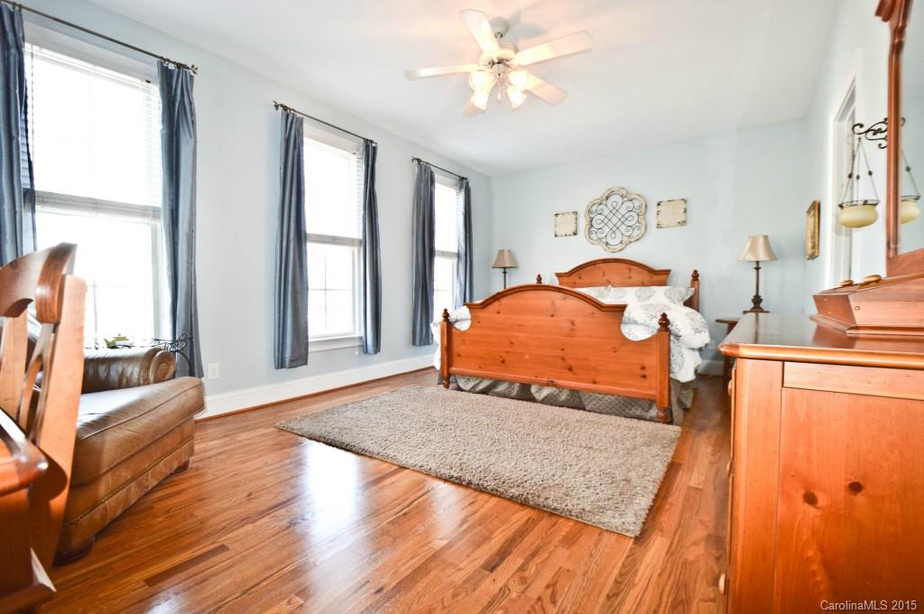 704 Shady Grove Crossing, Unit 496 Fort Mill, SC 29708 - Photo 14 of 20 a bedroom with a bed and wooden floor