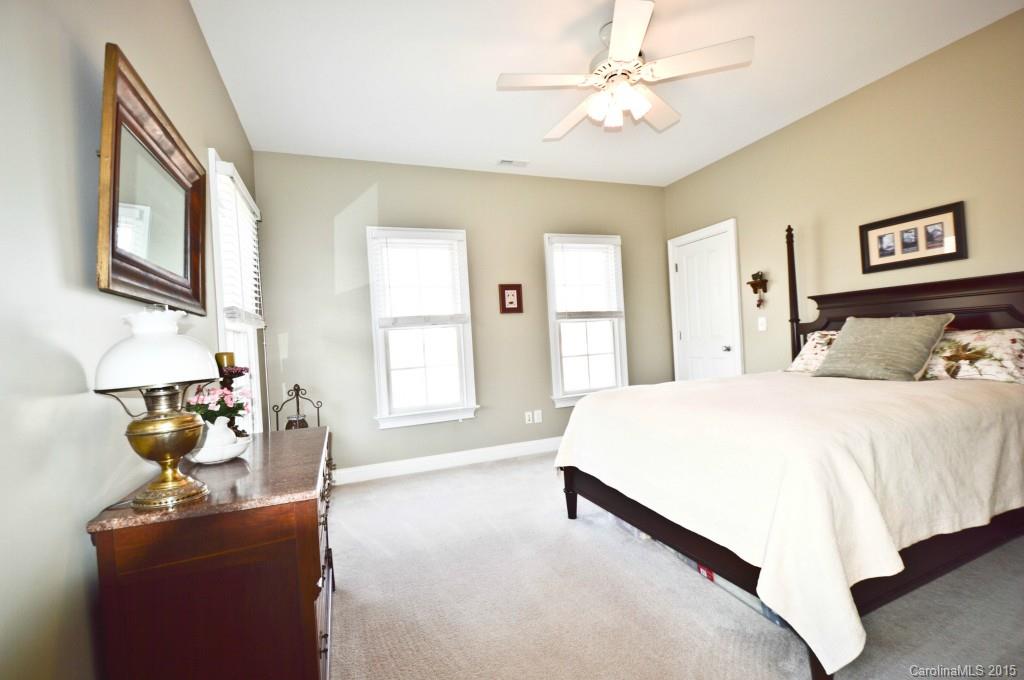 704 Shady Grove Crossing, Unit 496 Fort Mill, SC 29708 - Photo 17 of 20 a spacious bedroom with a bed and a chandelier