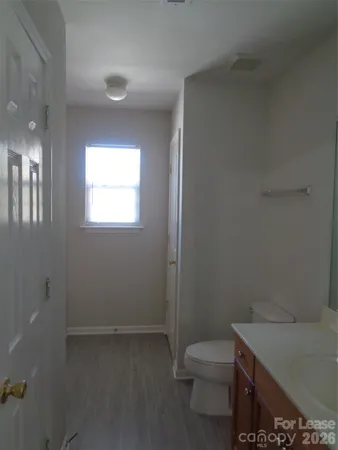a bathroom with a sink a toilet and window