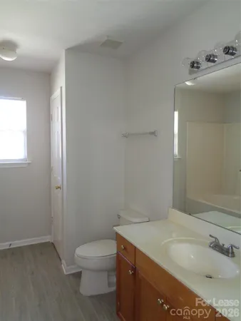 a bathroom with a granite countertop sink a toilet and a mirror