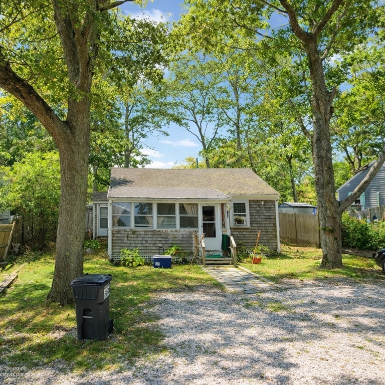 a front view of a house with a garden and trees