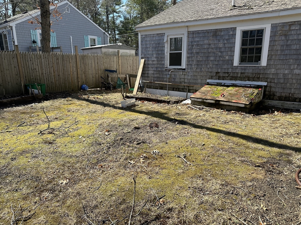163 Ninigret Avenue Mashpee, MA 02649 - Photo 12 of 17 a view of backyard with a wooden fence