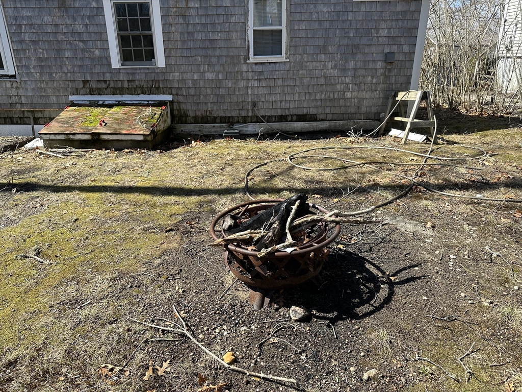 163 Ninigret Avenue Mashpee, MA 02649 - Photo 13 of 17 a view of a backyard with table and chairs