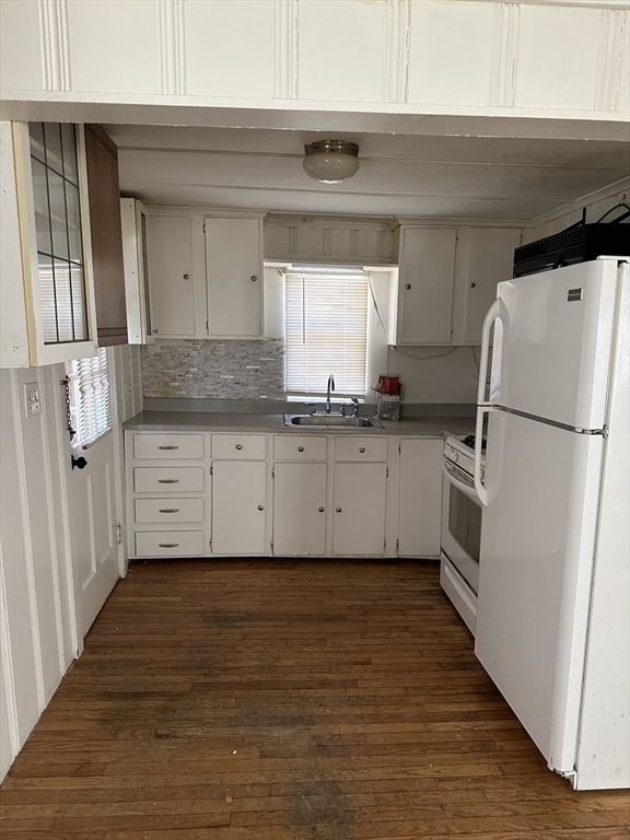 163 Ninigret Avenue Mashpee, MA 02649 - Photo 15 of 17 a kitchen with granite countertop a refrigerator a sink and white cabinets