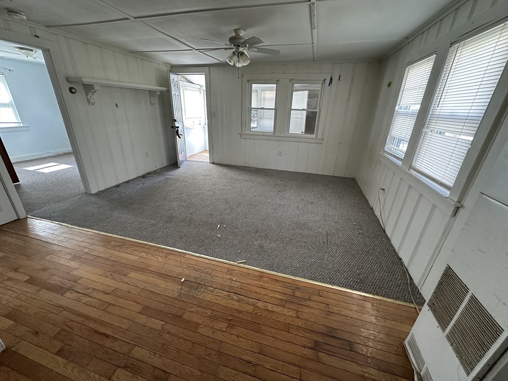 163 Ninigret Avenue Mashpee, MA 02649 - Photo 3 of 17 an empty room with wooden floor and windows