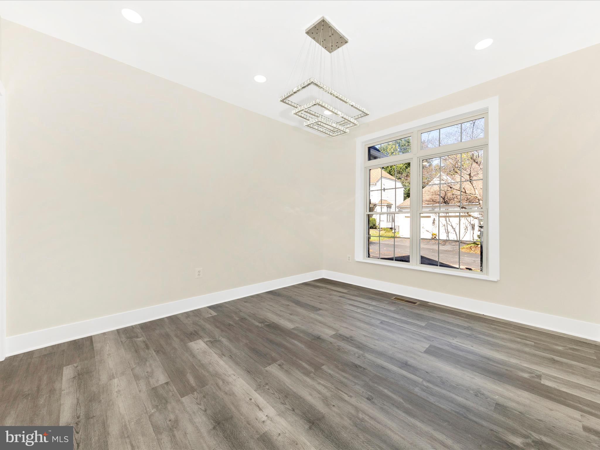 2621 Bear Den Road Frederick, MD 21701 - Photo 14 of 77 an empty room with wooden floor chandelier and windows