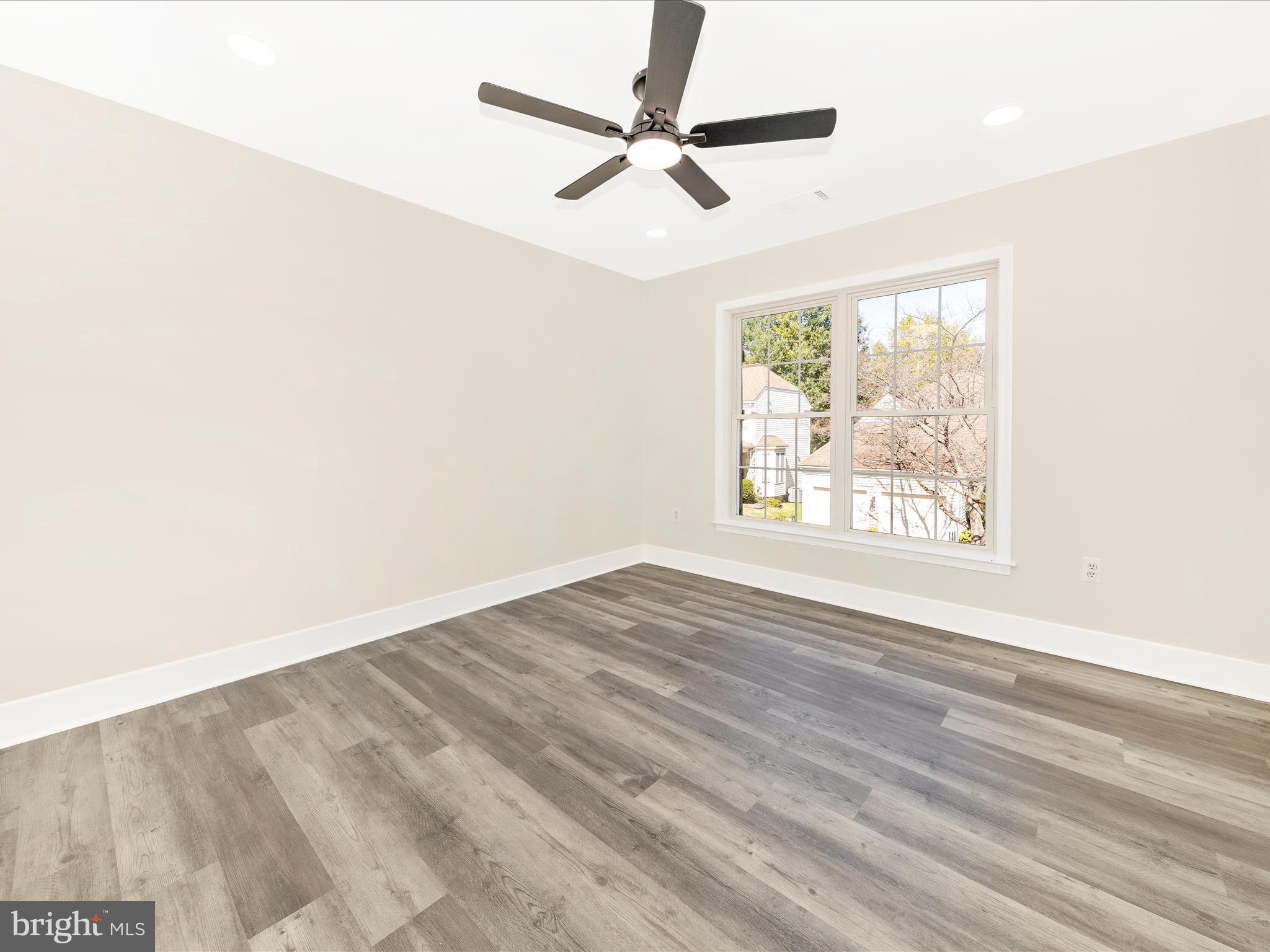 2621 Bear Den Road Frederick, MD 21701 - Photo 36 of 77 an empty room with wooden floor fan and windows