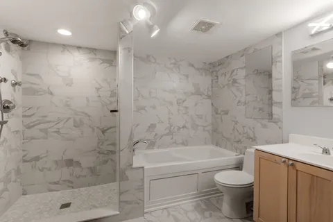 a bathroom with a shower a toilet and sink