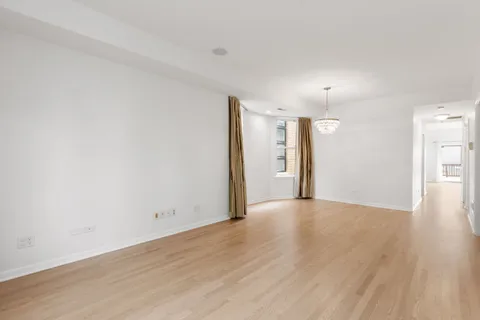 an empty room with wooden floor and window