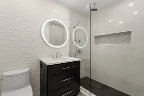 a bathroom with a sink a toilet and a mirror