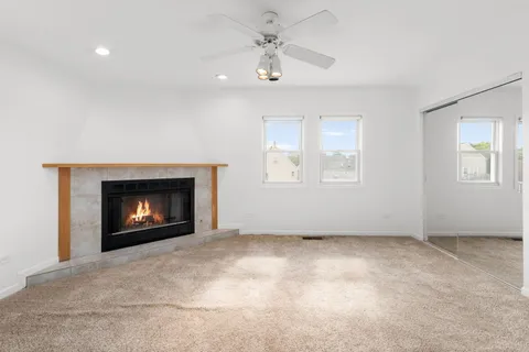 an empty room with windows and fireplace