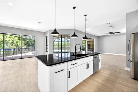 a kitchen with stainless steel appliances granite countertop a sink a stove and a wooden floors