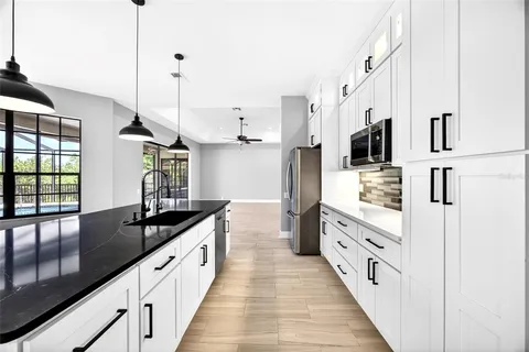 a large kitchen with granite countertop a sink and cabinets