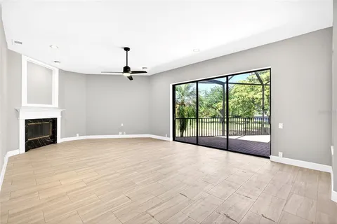 a view of an empty room with a fireplace and a window