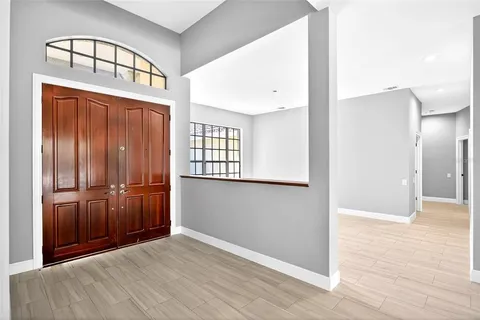 an empty room with wooden floor cabinet and windows