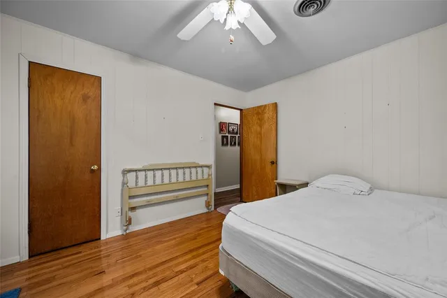 a bedroom with a bed and wooden floor