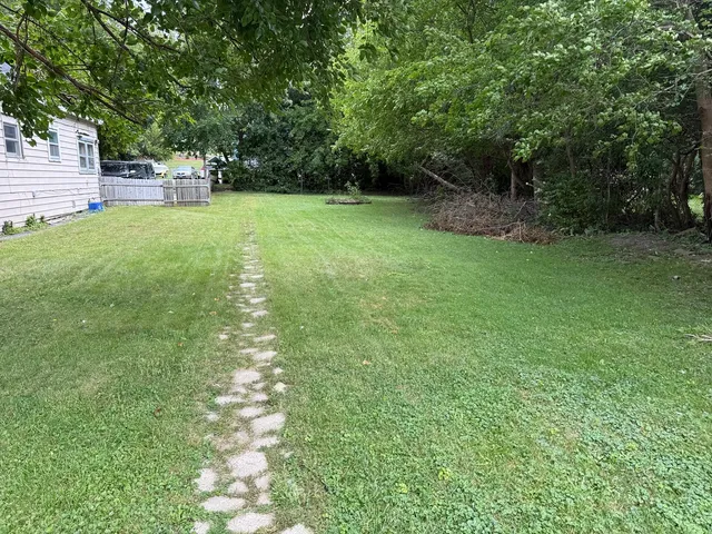a view of a yard with a house in the background