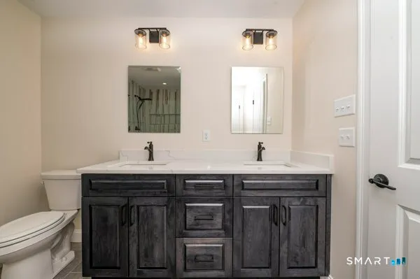 a bathroom with a toilet a sink and mirror