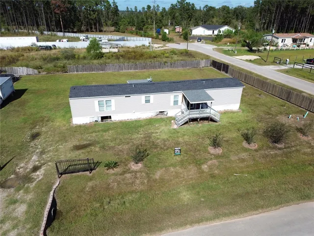 a view of a swimming pool with a yard and large trees