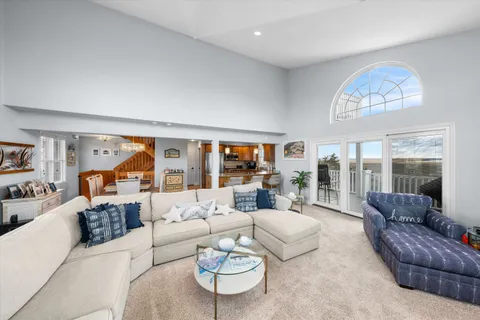 a living room with furniture a table and a large window