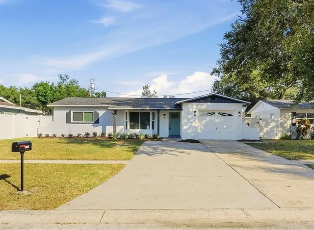 a front view of house with yard and trees around
