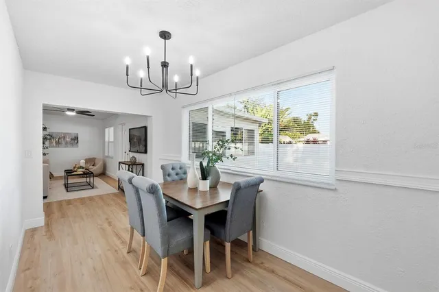 a view of a dining room with furniture a chandelier and wooden floor