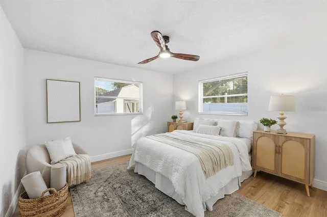 a bedroom with a bed couches chair and a window