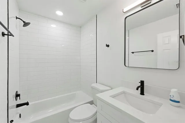 a bathroom with a bathtub shower sink vanity and toilet