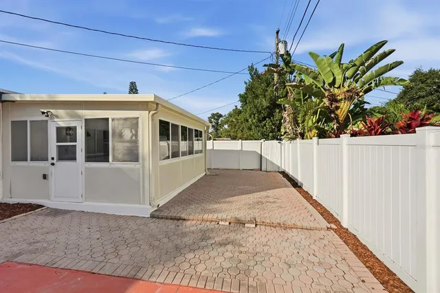 a view of a white house with wooden fence