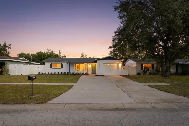 a front view of a house with a yard and trees