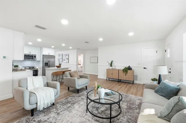 a living room with furniture and a view of kitchen