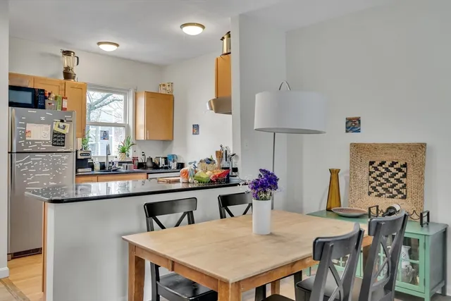 a kitchen with stainless steel appliances a table and chairs in it