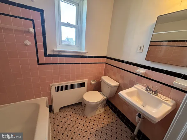 a bathroom with a toilet a sink and a window