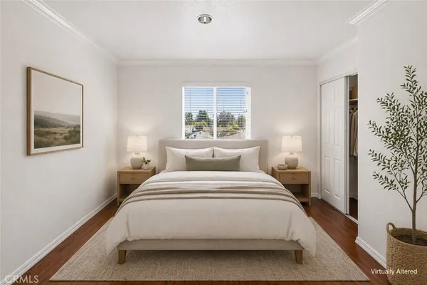a bedroom with a large bed and a potted plant