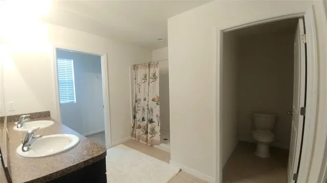 a bathroom with a granite countertop shower sink and mirror