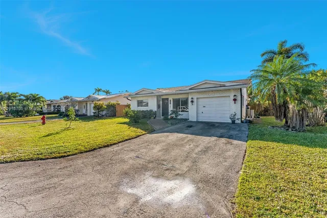 a view of a big house with a big yard and palm trees